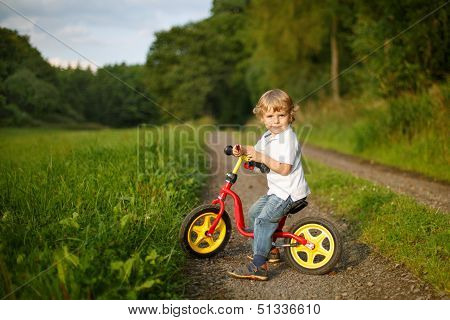 Little Toddler Boy Learning To Ride On His First Bike