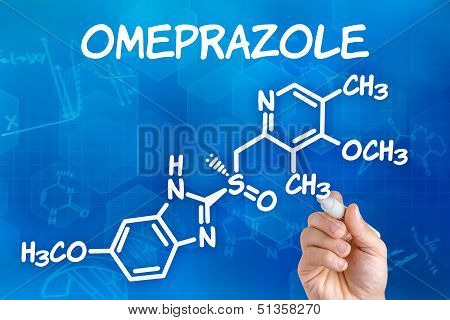 Hand with pen drawing the chemical formula of omeprazole