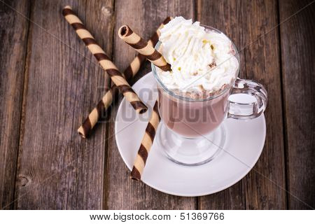 Hot chocolate with whipped cream topping, in glass with  rolled wafer. Vintage effect processing