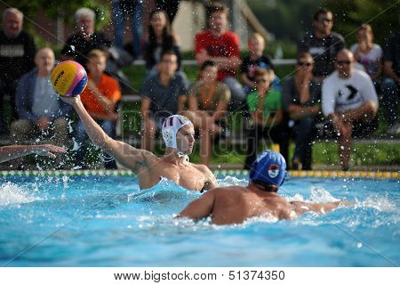 KAPOSVAR, HUNGARY - SEPTEMBER 15: Norbert Juhasz-Szelei (white) in action at a Hungarian championship waterpolo game between Kaposvar (white) vs Honved (blue) on September 15 2013 in Kaposvar, Hungary