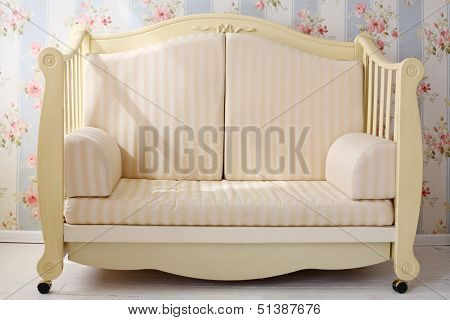 Beautiful light yellow small sofa in bright empty simple room.