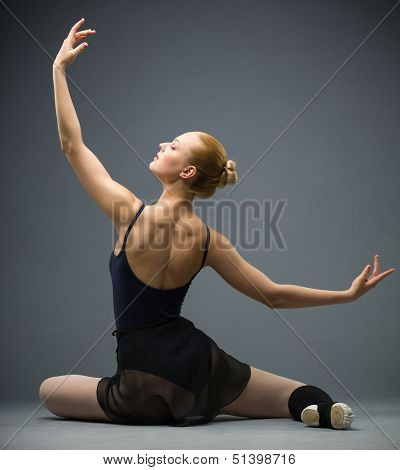Backview of dancing on the floor ballerina with hands up, isolated on white background on grey. Concept of elegant art and sportive hobby