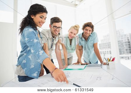 Group of fashion designers discussing designs in a studio
