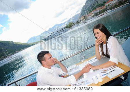 happy young couple having lanch at beautiful restaurant on the beach
