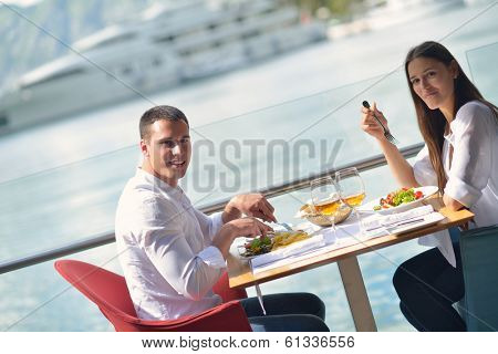 happy young couple having lanch at beautiful restaurant on the beach