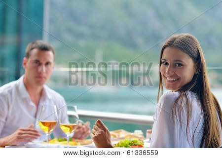 happy young couple having lanch at beautiful restaurant on the beach