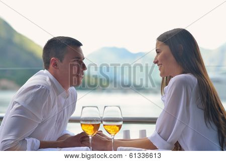 happy young couple having lanch at beautiful restaurant on the beach