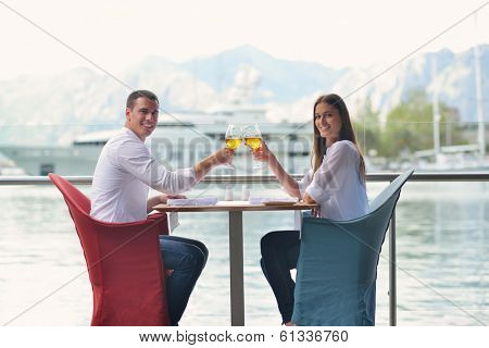 happy young couple having lanch at beautiful restaurant on the beach