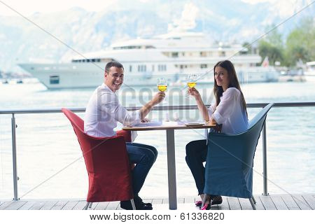 happy young couple having lanch at beautiful restaurant on the beach