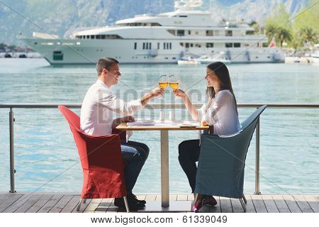 happy young couple having lanch at beautiful restaurant on the beach
