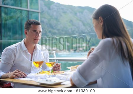 happy young couple having lanch at beautiful restaurant on the beach
