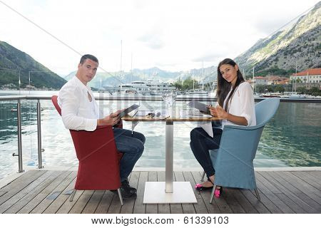 happy young couple having lanch at beautiful restaurant on the beach