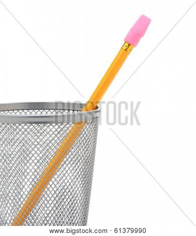 Closeup of a single pencil in a wire pencil cup isolated on white. The yellow pencil has a stick on pink eraser and is at an angle. 