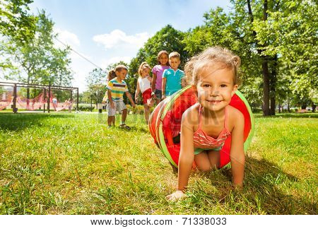 Cute group of kids play crawling in tube