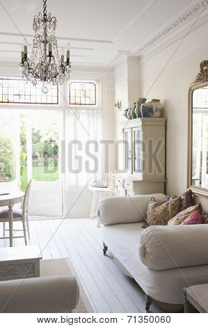 Daybed with cushions and glass chandelier in rustic home