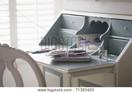 Letters tied up on writing desk at home