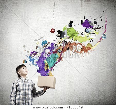 Young boy splashing colorful paint from carton box