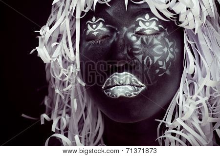 creative make up like Ethiopian mask, white pattern on black face close up