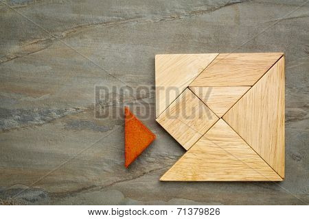 a missing piece in a square built from tangram pieces, a traditional Chinese puzzle game, slate rock background