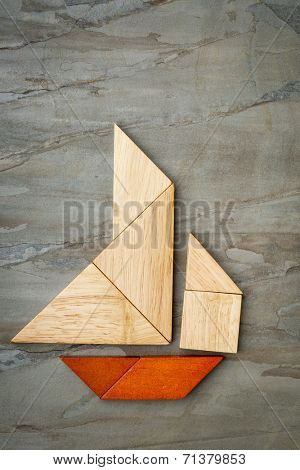 abstract picture of a sailing boat built from seven tangram wooden pieces over a slate rock background, artwork created by the photographer