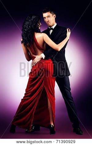 Beautiful young couple in love dancing passionate dance. Studio shot.