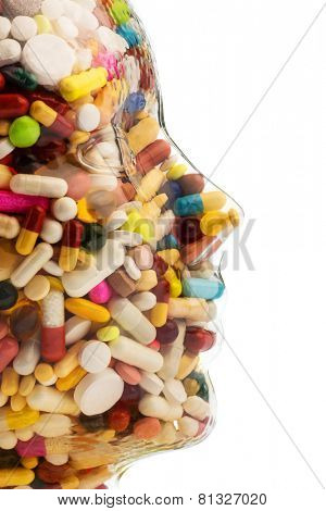 a head made of glass filled with many tablets. photo icon for drugs, abuse and addiction tablets