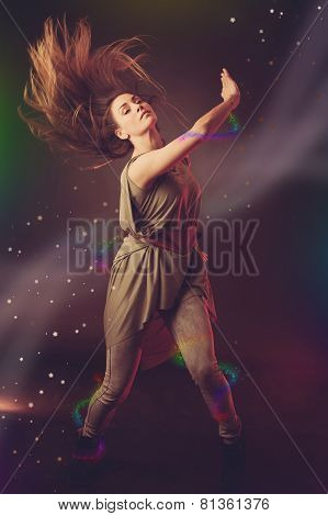 Beautiful Woman Dancer Dancing Over Dark Background With Light Rays And Star Swirls