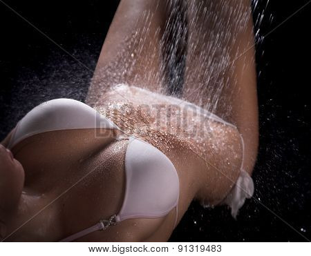 Beautiful and sex woman lays in white swimsuit, under shower