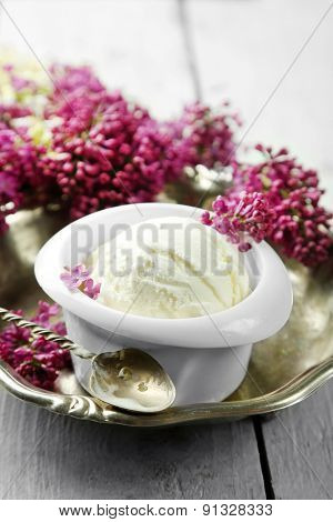 Beautiful composition with tasty ice cream and lilac flowers