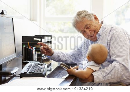 Senior Hispanic man with computer and baby