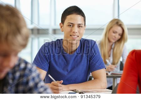 Hispanic teenage boy in class smiling to camera