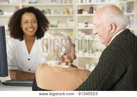 Senior couple in pharmacy with pharmacist