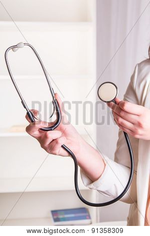 Doctor's hand holding a stethoscope in office