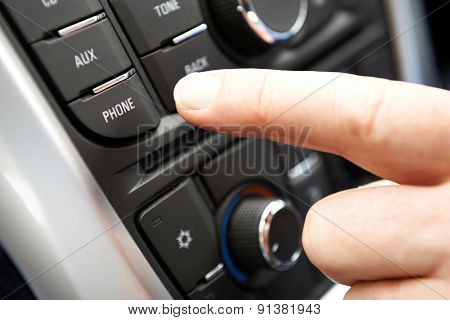 Close Up Of Hand Pressing Car Bluetooth Control On Dashboard