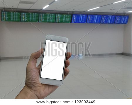 A man hand holding empty screen of smart phone and blur Flight Schedule in the airport terminal background.