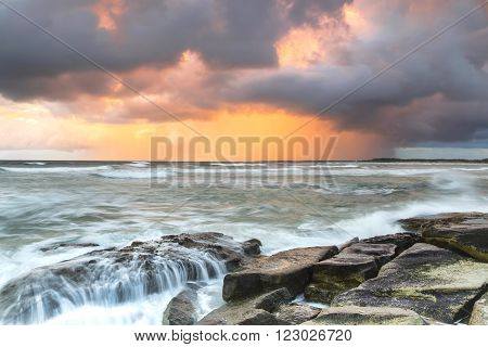 Stormy sunrise on the rocks at Queensland's Sunshine Coast, Caloundra