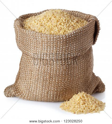 Bulghur or couscous in burlap bag with scattered heap isolated on white background
