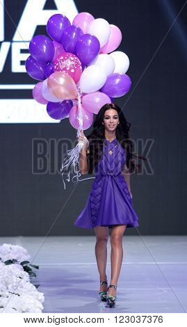 Sofia Bulgaria - March 23 2016: A model walks the runway with balloons at Sofia Fashion Week runway show. The fashion show is held for a second time in Bulgaria's capital.