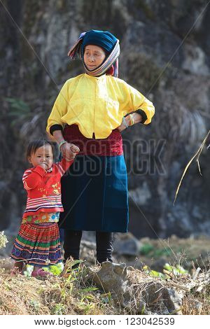 HA GIANG, VIETNAM - FEB 7, 2014: A group of unidentified Hmong women and children watching a traditional performance within a holiday called Tet under the sunlight of spring.