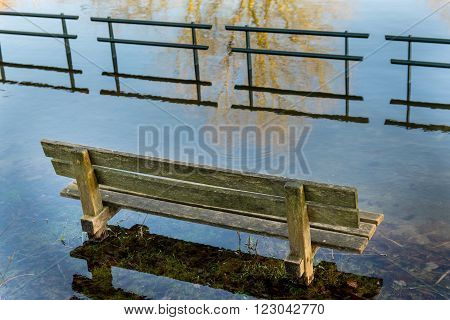 Flooded bench near a pond after heavy rains