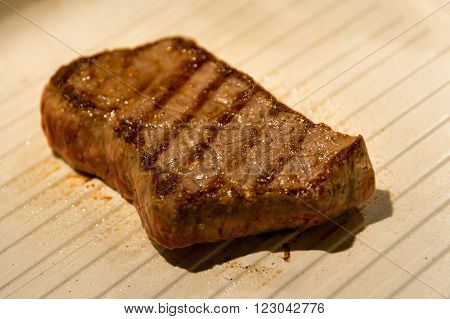 Steak sissling in a grill pan, awaiting consumption