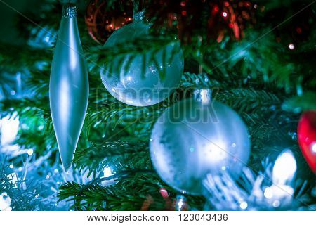 cold christmas balls and decorations hanging in a christmastree