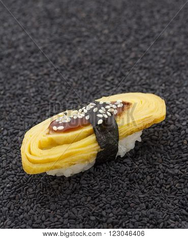 Tomago Sushi Nigiri On Black Sesame Background