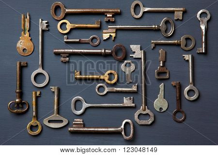 Set of old keys on a gray wooden board