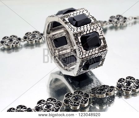 Silver bracelet with black gems on mirrorlike background
