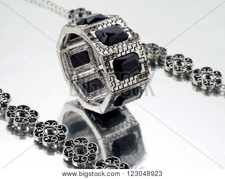 Silver bracelet with black gems on mirrorlike background