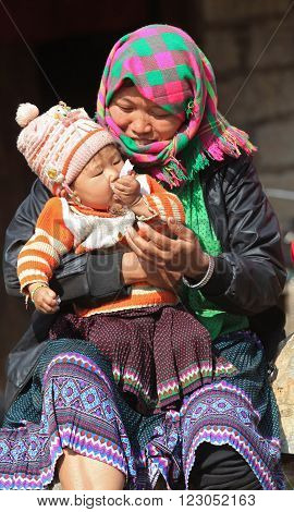 HA GIANG, VIETNAM - FEB 7, 2014: Unidentified Hmong woman holding her baby on arms in front of her house under the sunlight of spring.
** Note: Soft Focus at 100%, best at smaller sizes