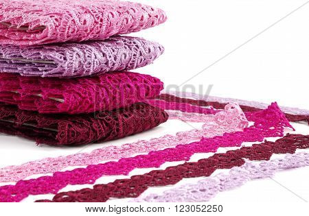 Reddish lace stretched over white background - pink, wine, raspberry-red