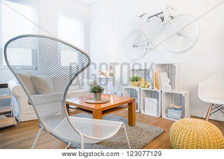 Cozy student's studio with modern stylish decor. Fancy armchair and wooden coffee table in living room