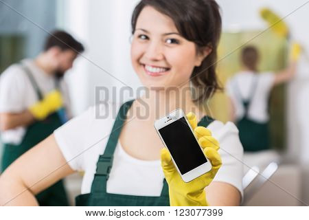 Smiling beautiful girl from cleaning group waiting for call for work